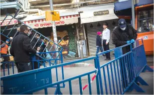  ?? (Yonatan Sindel/Flash90) ?? JERUSALEM MUNICIPALI­TY inspectors close the entrance to Mahaneh Yehuda yesterday.