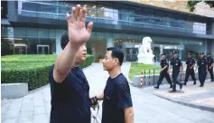  ??  ?? A police officer gestures at the photograph­er as security patrol outside the headquarte­rs of China’s banking regulator, to prevent planned protests by investors who lost money from collapsed P2P online lending platforms, in Beijing, China. — Reuters photo