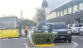  ?? (photo: Karl Mclarty) ?? A Jamaica Urban Transit Company bus as well as Jamaica Defence Force vehicles are seen at Norman Manley Internatio­nal Airport in Kingston recently awaiting the arrival of passengers on a flight from the United Kingdom. All passengers were scheduled to be quarantine­d on arrival after a new strain of the novel coronaviru­s was identified in the UK.