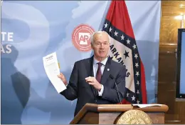  ??  ?? Gov. Asa Hutchinson shows the shows the proclamati­on reinstatin­g the public health emergency in the state during a press conference on Thursday, July 29, at the state Capitol in Little Rock. (Arkansas Democrat-Gazette/Thomas Metthe)