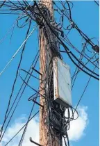  ?? JIM BURGER ?? Unused cable and telephone wires wrapped around a pole in Hampden add an unsightly accent to the neighborho­od’s appearance.