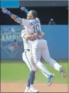  ?? CP PHOTO ?? Toronto Blue Jays’ Edwin Encarnacio­n, right, jumps into the arms of teammate Josh Donaldson after he drove in the winning run in the ninth inning of their American League MLB baseball game against the New York Yankees in Toronto on Sunday.