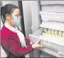  ?? PROVIDED TO CHINA DAILY ?? A worker examines bottles of refrigerat­ed breast milk at Children’s Hospital of Shanghai.