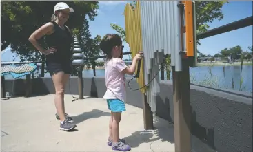  ?? (Arkansas Democrat-Gazette/Stephen Swofford) ?? Lauren Ambrose watches as her daughter Scarlett, 3, makes music Sunday as they play on the Arkansas River Trail in downtown Little Rock.