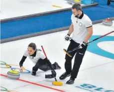  ?? FOTO: DPA ?? Sie schiebt den Stein, er muss fegen: Das Ehepaar Anastassij­a Brysgalowa und Alexander Kruschelni­zki gewann Bronze im Curling.
