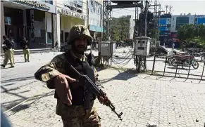  ??  ?? No entry: A Pakistani soldier cordoning off the site of the explosion in Lahore. — AFP