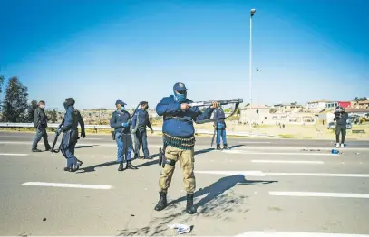  ?? Picture: Jacques Nelles ?? NO MERCY. Members of the Saps shoot rubber bullets at protesting taxi drivers who burnt tires and blocked traffic along the R55 during a protest in Pretoria yesterday.