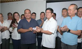  ?? ?? Ewon (left) handing Lasimbang his membership card.