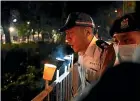  ?? AP ?? Police officers in Hong Kong blow out candles lit by people marking the anniversar­y of the military crackdown on a pro-democracy student movement in Beijing.