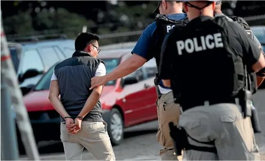  ?? AP ?? A man is taken into custody at a Koch Foods Inc. plant in Morton, Mississipp­i, as immigratio­n officials raided several Mississipp­i food processing plants.