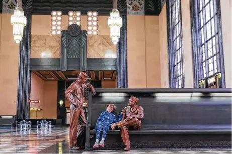  ?? Matt Miller photos ?? Illyana Kelley, 9, seems to be regaled by the stories of these servicemen, two of the lifelike statues placed around the Durham Museum in Omaha, in the 86-year-old confines of the former Union Station.