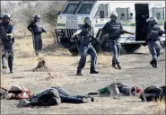  ?? PICTURE: REUTERS ?? TRAGIC SCENE: Policemen keep watch over striking miners after the shooting near Marikana mine on August 16, 2012: