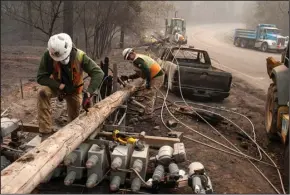  ?? JOEL ANGEL JUAREZ/ZUMA PRESS ?? PG&E workers dissemble broken power lines on Nov. 15, 2018, after the Camp Fire ripped through Paradise.