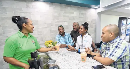  ??  ?? Althia Mcpherson, proprietor of Thia’s Juice Bar, serves delicious fruit smoothies to FLOW managers (from left) Pete Smith, Dwight Williams, Kecia Taylor, and Carlo Redwood during the official opening ceremony of the new FLOW Flex gym.