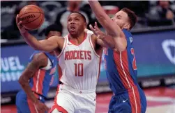  ?? CARLOS OSORIO/AP ?? Houston Rockets guard Eric Gordon (10) attempts a layup as Detroit Pistons forward Blake Griffin defends during the second half Friday night in Detroit.