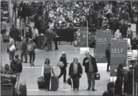  ?? The Associated Press ?? HOLIDAY TRAVEL: Passengers pass through Terminal A on Nov. 22 at Logan Internatio­nal Airport in Boston. It’s getting late for booking holiday travel, but not too late. Experts say there are tips for procrastin­ators to find affordable airfares and hotel...