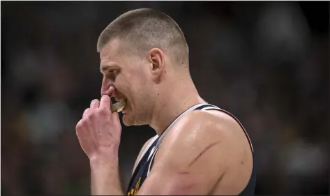  ?? PHOTOS BY AARON ONTIVEROZ — THE DENVER POST ?? Denver’s Nikola Jokic puts his mouthguard in after earning a technical foul during the third quarter against the Sacramento Kings at Ball Arena in Denver on Wednesday.