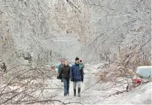  ?? RYAN REMIORZ, THE CANADIAN PRESS ?? Jan. 6, 1998: Pedestrian­s make their way past downed trees as an ice storm ripped through Montreal.