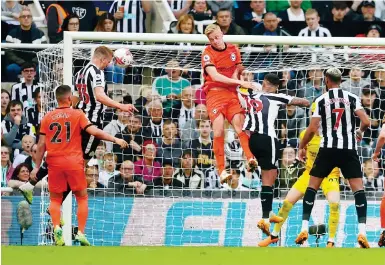  ?? Photo: Reuters ?? Newcastle United’s Dan Burn heads the ball into the net for his team’s second goal against Brighton at St James’ Park.