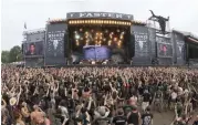  ?? — AFP ?? Festival goers ( down) stand in front of the main stage of the heavy metal festival in Sacken, northern Germany on Monday.