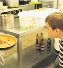  ??  ?? Ethan Clarke watches a chef prepare a curry