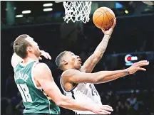  ??  ?? Milwaukee Bucks’ center Miles Plumlee (18) watches as Brooklyn Nets’ forward Rondae Hollis-Jefferson (24) goes up for a layup in the second half of an NBA basketball game, on Dec 1, in New York. The Bucks defeated
the Nets 111-93. (AP)