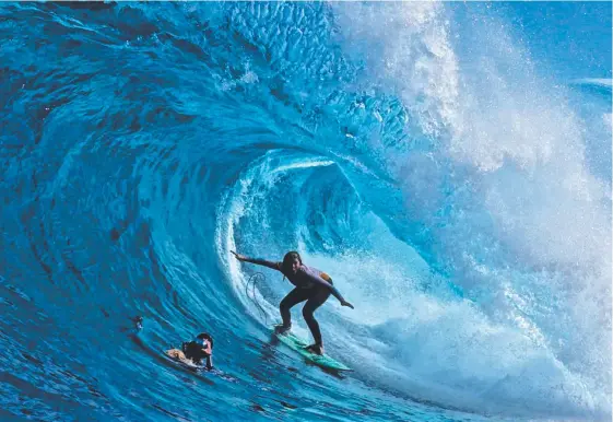  ??  ?? Tasmanian surfer Lizzie Stokely pulls into one of the biggest and best barrels of her life at Shipstern Bluff in