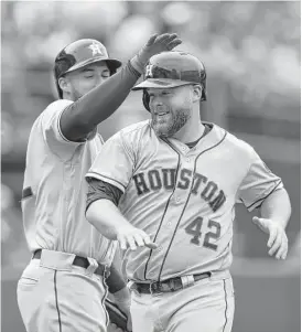 ?? Ben Margot / Associated Press ?? Though he didn’t start Saturday’s game, Brian McCann, right, contribute­d a single, a run, an RBI and two walks as the Astros rallied to beat the Athletics.