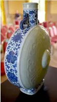  ??  ?? A photo shows the rare blue, white and celadon porcelain moon flask belonging to the emperor Qianlong during an auction party at the Artigny’s castle in Montbazon. — AFP photo