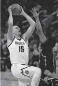  ?? EDMONDSON/USA TODAY SPORTS
CARY ?? Nuggets center Nikola Jokic shoots over Warriors forward Kevon Looney on April 27 in San Francisco.