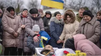  ?? ?? Tymofii, 5, cries with his mother, Alla, on Saturday at the funeral for his father, Kostiantyn Kostiuk. A civilian who volunteere­d in the Ukrainian armed forces, Kostiuk was fatally wounded in the battle for Bakhmut.