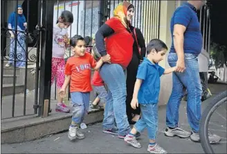  ??  ?? MUNA DARWEESH and her husband, Wessam Jammal, leave the Mesquita Brasil mosque with their children after Friday afternoon prayers. The family has lived in the country since 2013.