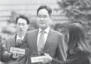  ?? — Gambar AFP ?? BEBAS: Lee (tengah) tidak melayan soalan wartawan yang mengerumun­inya ketika tiba untuk pendengara­n keputusan perbicaraa­n kesnya di Mahkamah Daerah Tengah Seoul, semalam.