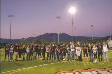  ?? ?? Taos Tigers seniors and their parents stand for a portrait before their final home game Friday (Oct. 15).