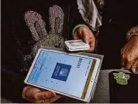  ?? ?? Mandy Lin holds a tablet and card reader for cashless payments at Golden King Vietnamese Restaurant.