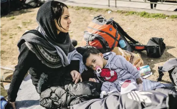  ?? BILD: SN/AFP ?? Eine Mutter und ihr Kind rasten auf dem Viktoria-Platz in Athen. Hunderte Flüchtling­e und Migranten haben sich dort versammelt.
