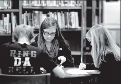  ??  ?? Springdale High sophomores
NWA Media/JASON IVESTER
Garrett Story (from left), Cassidy King and Allie Dill study for their final exams Friday in the school library. A U.S. Education Department grant will help the district rethink high school and focus...