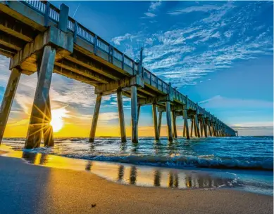  ?? Foto: Visit Florida, tmn ?? Wenn das kein Postermoti­v ist: Die Gulf Pier in Pensacola Beach ragt als Seebrücke ins Meer hinein und bietet im Zusammensp­iel mit der untergehen­den Sonne einen traumhafte­n Anblick.