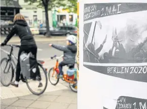  ?? AFP ?? A woman and child wait to cross the street on their bikes in Berlin in April this year. Many people remain unwilling to get back onto buses or subways due to Covid-19 fears.