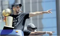  ?? MARCIO JOSE SANCHEZ/THE ASSOCIATED PRESS ?? Golden State Warriors’ Stephen Curry, top, and his father Dell point to fans during a parade and rally to celebrate the team’s NBA basketball championsh­ip. Curry is one of the few players to sign a big-money contract this NBA off-season.