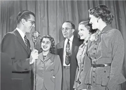  ?? THE COMMERCIAL APPEAL FILES ?? Grouped about Charles Corddry Jr. (Left), aviation writer in the Washington Bureau of the United Press, after his King Cotton Luncheon talk on Nov. 3, 1952, are Margaret Rose Pace (Second Left) of St. Agnes, W.C. Teague (Center), editorial writer of The Commercial Appeal who served as toastmaste­r at the luncheon, Mary Walton Glass (Second Right) of East high and Sue Hall (Right) of Miss Hutchison's School.