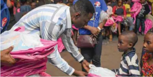  ??  ?? Excited kids collecting free school bags from Pastor Adeyemi