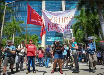  ?? GIORGIO VIERA — AFP VIA GETTY IMAGES ?? Trump supporters and protesters hold signs in front of the Wilkie D. Ferguson Jr. U. S. Courthouse before the arraignmen­t of former President Donald Trump in Miami, Florida, on Tuesday.