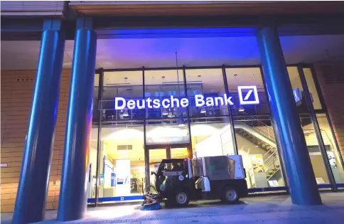  ??  ?? A road cleaning machine drives past a Deutsche Bank bank branch in Berlin on Sept 28, 2016. — WP-Bloomberg photo