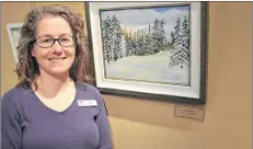  ?? SALLY COLE/THE GUARDIAN ?? Staff member Pam Wheatley stands next to “Glow of the Sunset”, a winter scene by Millie Kikkert at the Cornwall Library Art Gallery.