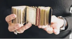  ?? Charlie rubin / the new York times ?? Patricia Pistner holds one of about 950 books from her collection on display at “A matter of Size: miniature Bindings and texts from the Collection of Patricia J. Pistner,” at the Grolier Club in new York.