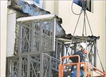  ?? Mark Boster Los Angeles Times ?? ENGINEERS LOOK for clues after a balcony collapsed at the Library Gardens in Berkeley. The victims were largely students from Ireland who were working in the Bay Area for the summer.