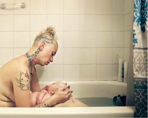  ?? Photograph­s by Christina House Los Angeles Times ?? MCKENZIE tenderly bathes her daughter, Ann, in their apartment. She was provided transition­al housing for women ages 18 to 24 who are expecting or have children under 5.