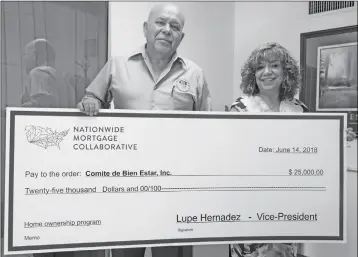  ?? PHOTO BY CESAR NEYOY/BAJO EL SOL ?? TONY REYES, EXECUTIVE DIRECTOR OF THE COMITE DE BIENESTAR, and Maria Aguirre, also of the Comite, hold up a facsimile check for $25,000 from the Nationwide Mortgage Collaborat­ive, to start a program to help qualifying families apply for low-interest...