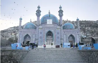  ?? SIDDIQULLA­H ALIZAI, THE ASSOCIATED PRESS ?? Afghans walk outside Hazara’s Sakhi Shrine in Kabul, Afghanista­n. The country’s Tourism Directorat­e is aiming to bring more foreigners to sample its history and sites.